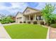 Inviting single-Gathering home with a covered porch, lush green lawn, and mature trees at 14360 W Windrose Dr, Surprise, AZ 85379