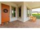 Inviting front porch with decorative door, rocking chairs, and brick-paved patio at 14360 W Windrose Dr, Surprise, AZ 85379