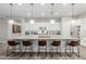 Kitchen island with granite countertop and bar stool seating, illuminated by pendant lights at 14360 W Windrose Dr, Surprise, AZ 85379