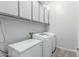 Bright laundry room with ample storage cabinets, modern washer, and dryer appliances at 14360 W Windrose Dr, Surprise, AZ 85379