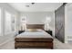 Stylish main bedroom featuring a wooden bed frame, modern lighting, and a barn door to the bathroom at 14360 W Windrose Dr, Surprise, AZ 85379