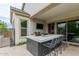 Inviting outdoor kitchen with a built-in grill, sink, and marble countertop with bar seating at 14360 W Windrose Dr, Surprise, AZ 85379