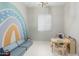 Bright playroom with rainbow wall art, plush sofa, table and chairs, and playful decor at 14360 W Windrose Dr, Surprise, AZ 85379