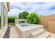 An outdoor pool features patterned tile, a water feature, and manicured hedges at 14360 W Windrose Dr, Surprise, AZ 85379