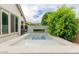 The outdoor pool has clean water and a water feature plus green foliage in the background at 14360 W Windrose Dr, Surprise, AZ 85379