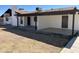 Home's backyard featuring a large covered patio with two doors and a window at 1440 E Grove Ave, Mesa, AZ 85204