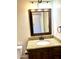 Bathroom featuring a dark wood vanity, granite counters, and decorative framed mirror at 1440 E Grove Ave, Mesa, AZ 85204