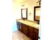 Bathroom featuring a dual sink vanity, granite counters, tile floors, and decorative framed mirrors at 1440 E Grove Ave, Mesa, AZ 85204