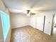 Bedroom featuring a large window, tile floor, and dual door closet at 1440 E Grove Ave, Mesa, AZ 85204