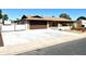 Spacious driveway leads up to a well-kept home featuring a two-car garage and manicured landscaping at 1440 E Grove Ave, Mesa, AZ 85204