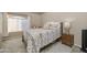 Cozy bedroom featuring a queen bed, a stylish grey and beige quilt, and a light-filled arched window at 14728 W Cheery Lynn Dr, Goodyear, AZ 85395