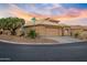 Corner-lot house with two-car garage and desert landscaping against a vibrant sunset backdrop at 14728 W Cheery Lynn Dr, Goodyear, AZ 85395