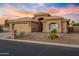 Charming single-story home boasts a two-car garage, desert landscaping and an inviting front entrance at 14728 W Cheery Lynn Dr, Goodyear, AZ 85395