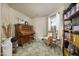 Cozy living room with piano, tile flooring, bookshelf, a comfortable chair, and plenty of natural light at 14728 W Cheery Lynn Dr, Goodyear, AZ 85395