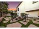 Inviting backyard area with stone pavers, a cozy fire pit, seating and lush landscaping at 14820 N 44Th Pl, Phoenix, AZ 85032