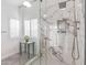 Modern bathroom with a glass shower, marble-style tiles, and a bright window with plantation shutters at 14820 N 44Th Pl, Phoenix, AZ 85032