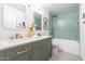 Bathroom featuring double sinks, marble countertops, gold fixtures, and a green tiled shower with a tub at 14820 N 44Th Pl, Phoenix, AZ 85032