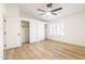 Spacious bedroom with light hardwood floors, white walls, and a ceiling fan at 14820 N 44Th Pl, Phoenix, AZ 85032