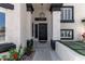 Inviting front entrance with a black front door, modern lighting, and manicured landscaping at 14820 N 44Th Pl, Phoenix, AZ 85032