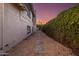 Stone pavers lead down a side yard bordered by a wall of manicured hedges at 14820 N 44Th Pl, Phoenix, AZ 85032