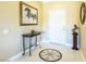 Elegant entryway with tiled floor design, decorative table, artwork, and view of the front door at 16416 W Rock Springs Ln, Surprise, AZ 85374