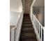 Carpeted staircase with white railings leading to the upper level of the home at 17345 N Costa Brava Ave, Maricopa, AZ 85139