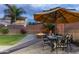 Inviting backyard patio featuring a dining set, fire pit, lush green grass, and privacy fence at 17507 W Fetlock Trl, Surprise, AZ 85387