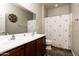 Neutral bathroom features double sinks and a shower with decorative curtain at 17507 W Fetlock Trl, Surprise, AZ 85387