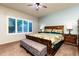 A spacious bedroom with hardwood furniture, ceiling fan, and a window with shutters at 17507 W Fetlock Trl, Surprise, AZ 85387