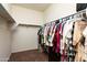 An organized walk-in closet with hanging clothes and shelves, offering ample storage space at 17507 W Fetlock Trl, Surprise, AZ 85387