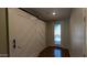 Inviting entryway with hardwood floors, decorative glass front door and stylish sliding barn door at 17507 W Fetlock Trl, Surprise, AZ 85387