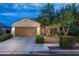 Charming home with a two-car garage, desert landscaping, and mature tree in the well-maintained front yard at 17507 W Fetlock Trl, Surprise, AZ 85387