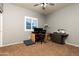 A functional home office space with a desk, chair, and printer on a carpeted floor at 17507 W Fetlock Trl, Surprise, AZ 85387