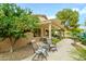 Back patio featuring a pergola, seating area, an orange tree, and desert landscaping at 17553 N Thornberry Dr, Surprise, AZ 85374