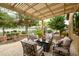 Back patio featuring a pergola, seating area, desert landscaping, and access to the putting green at 17553 N Thornberry Dr, Surprise, AZ 85374