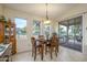 Dining room with a wood table, four chairs, chandelier, and view of the backyard and grill at 17553 N Thornberry Dr, Surprise, AZ 85374