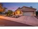 Charming home exterior with a two-car garage, a landscaped yard, and an arched courtyard entry at 17553 N Thornberry Dr, Surprise, AZ 85374