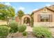 Close up shot of the decorative gate and entryway in the well manicured front yard at 17553 N Thornberry Dr, Surprise, AZ 85374