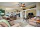 Spacious living room open to kitchen area, featuring tile floors and a ceiling fan at 17553 N Thornberry Dr, Surprise, AZ 85374