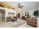 Bright living room with comfortable seating, arched doorways, and a decorative ceiling fan at 17553 N Thornberry Dr, Surprise, AZ 85374