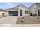 Charming single-Gathering home features a gray garage door, stone accents, and low-maintenance landscaping at 17819 W Mission Ln, Waddell, AZ 85355