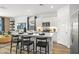 Modern kitchen featuring a kitchen island with black chairs, white cabinets, and stainless steel appliances at 17819 W Mission Ln, Waddell, AZ 85355