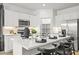 Bright kitchen features stainless steel appliances, white cabinetry, and a marble countertop island with bar stool seating at 17819 W Mission Ln, Waddell, AZ 85355