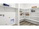 Functional laundry room with modern shelving, washer/dryer hookups, and ample storage space at 17819 W Mission Ln, Waddell, AZ 85355