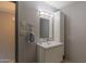 This light and bright bathroom has a pedestal sink, large mirror, and updated light fixture at 2212 W Claremont St, Phoenix, AZ 85015