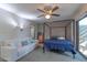 This main bedroom features a ceiling fan, modern lighting, a door to the exterior, and a comfortable white sofa at 2212 W Claremont St, Phoenix, AZ 85015