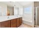 Bright bathroom with dual sinks, wood cabinets, a large mirror, and a bathtub at 23689 W Watkins St, Buckeye, AZ 85326