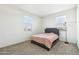 Bedroom with neutral carpet, two windows, and a gray upholstered headboard at 23689 W Watkins St, Buckeye, AZ 85326