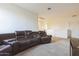 Large living room area with a leather sectional sofa, neutral carpet, and a television at 23689 W Watkins St, Buckeye, AZ 85326