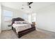 Bright main bedroom with a padded headboard, ceiling fan, and view into the bathroom at 23689 W Watkins St, Buckeye, AZ 85326